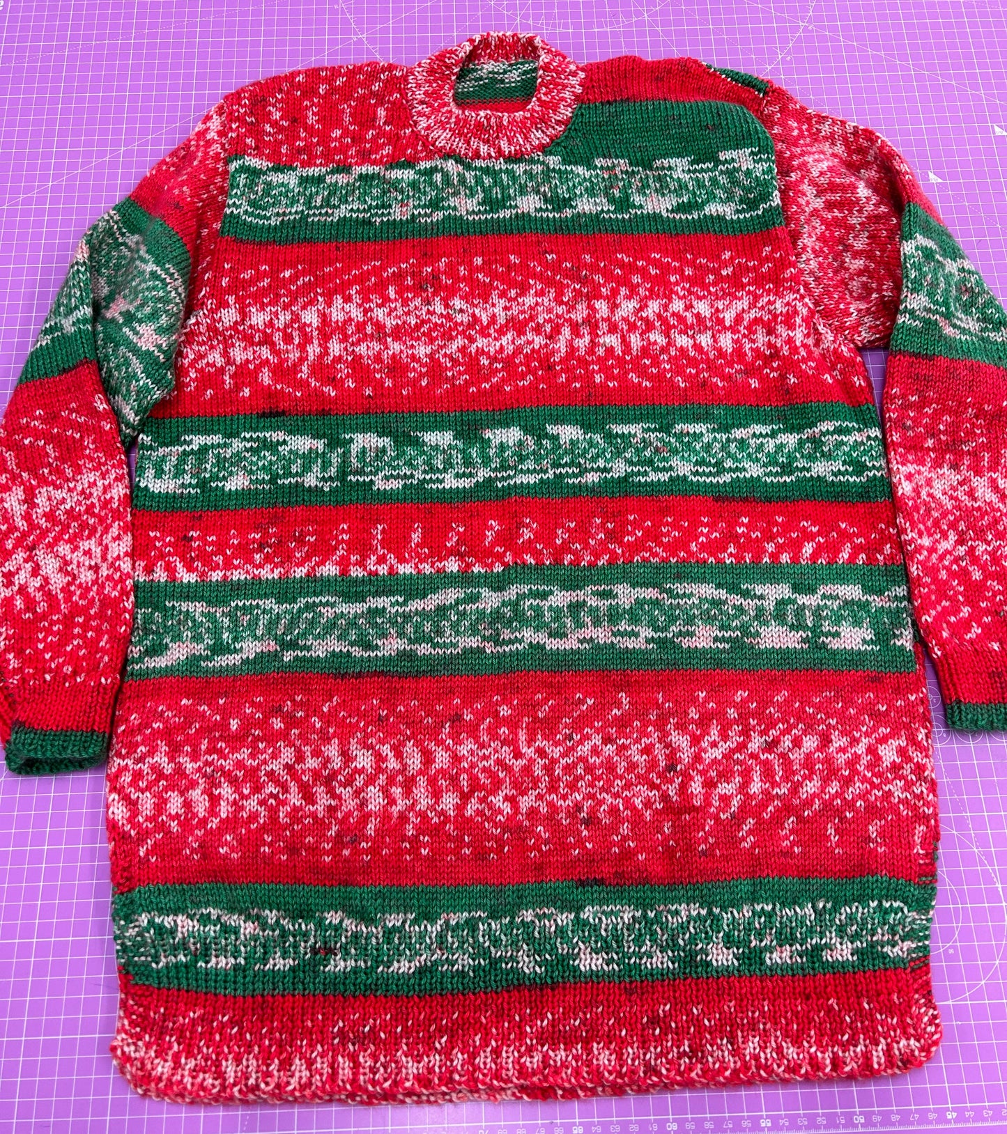 Red and green striped sweater on a purple cutting mat
